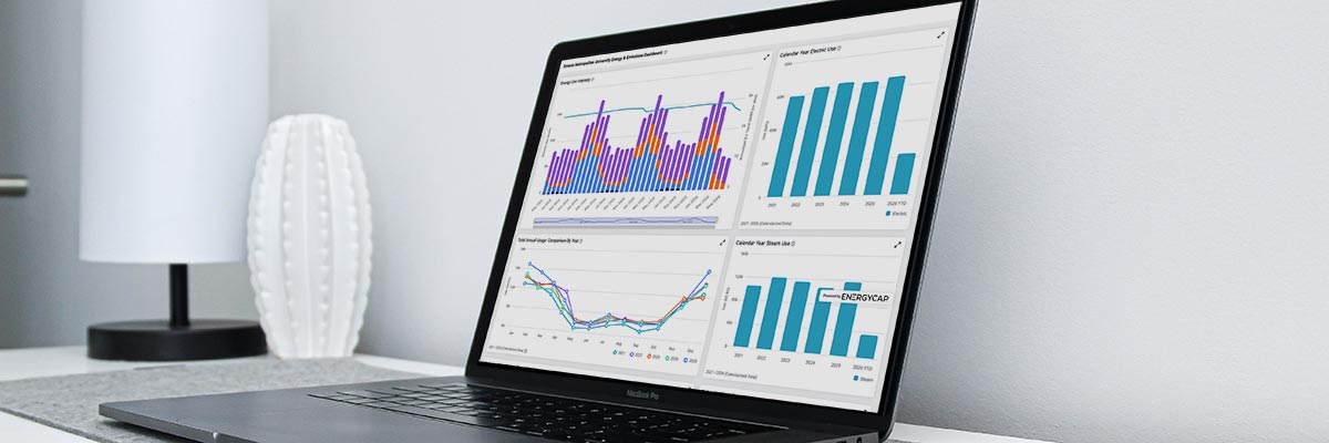 A laptop showing the TMU Energy and Emissions dashboard on its screen.