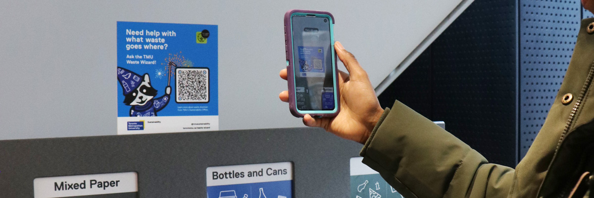 Waste Wizard qr code being scanned by phone at four-stream waste receptacle.