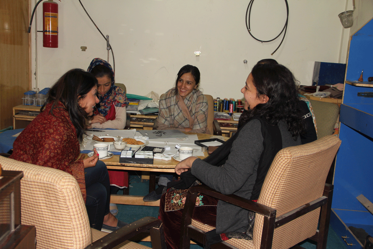 Farrukh and three artisans sitting and laughing together 