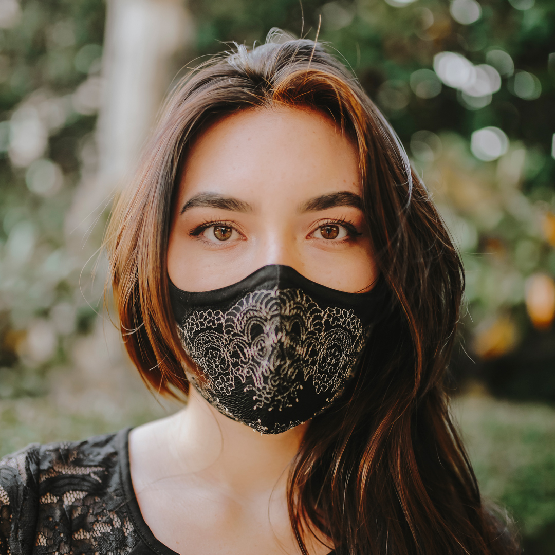 woman wearing a reusable face mask and looking at camera