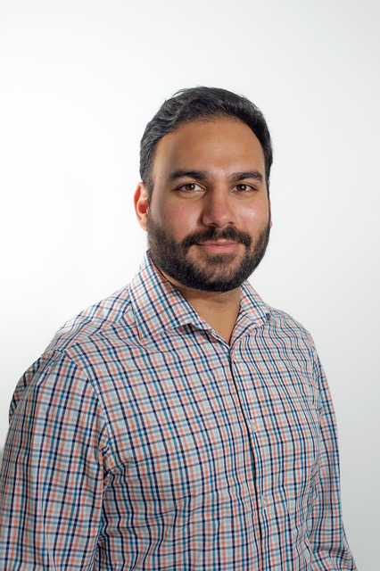 Image of man (Arun) wearing a plaid button up smiling 