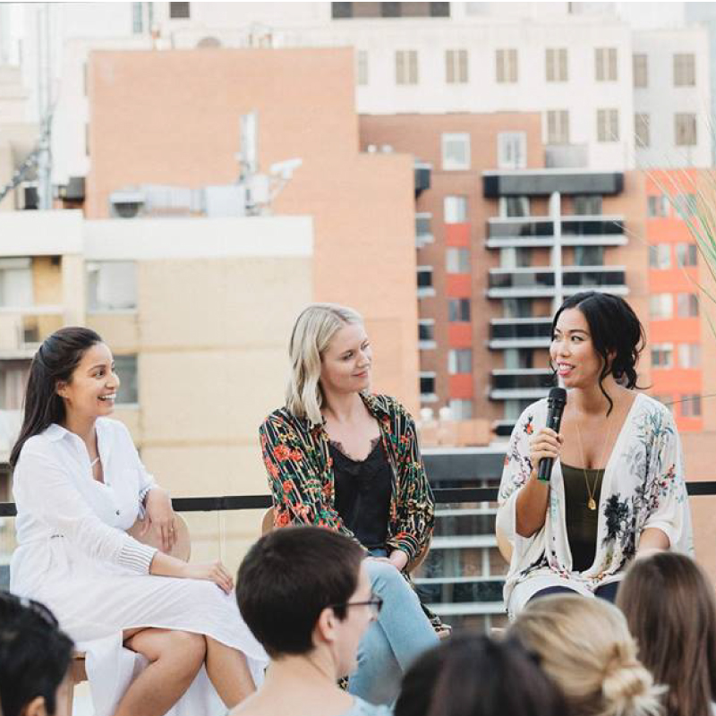 women speaking at an event with an audience