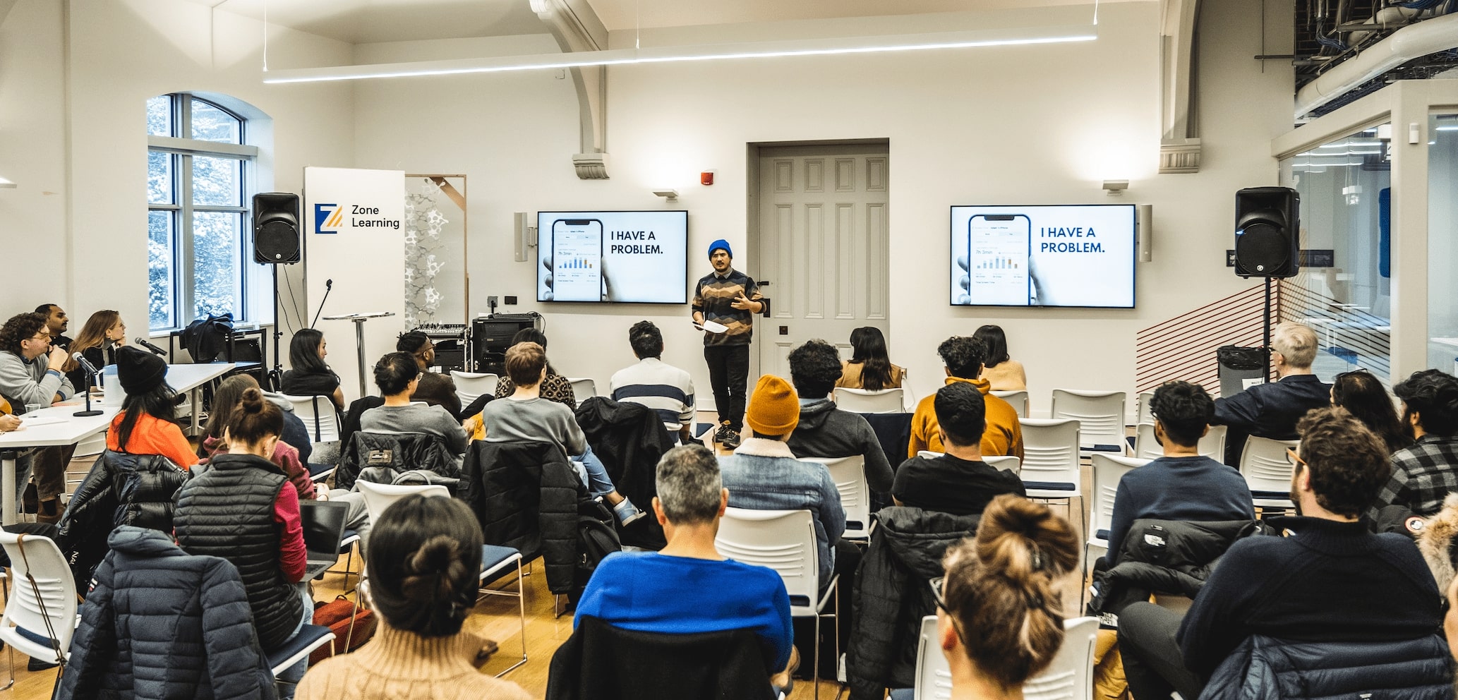 Group of people sitting in a room watching a presentation