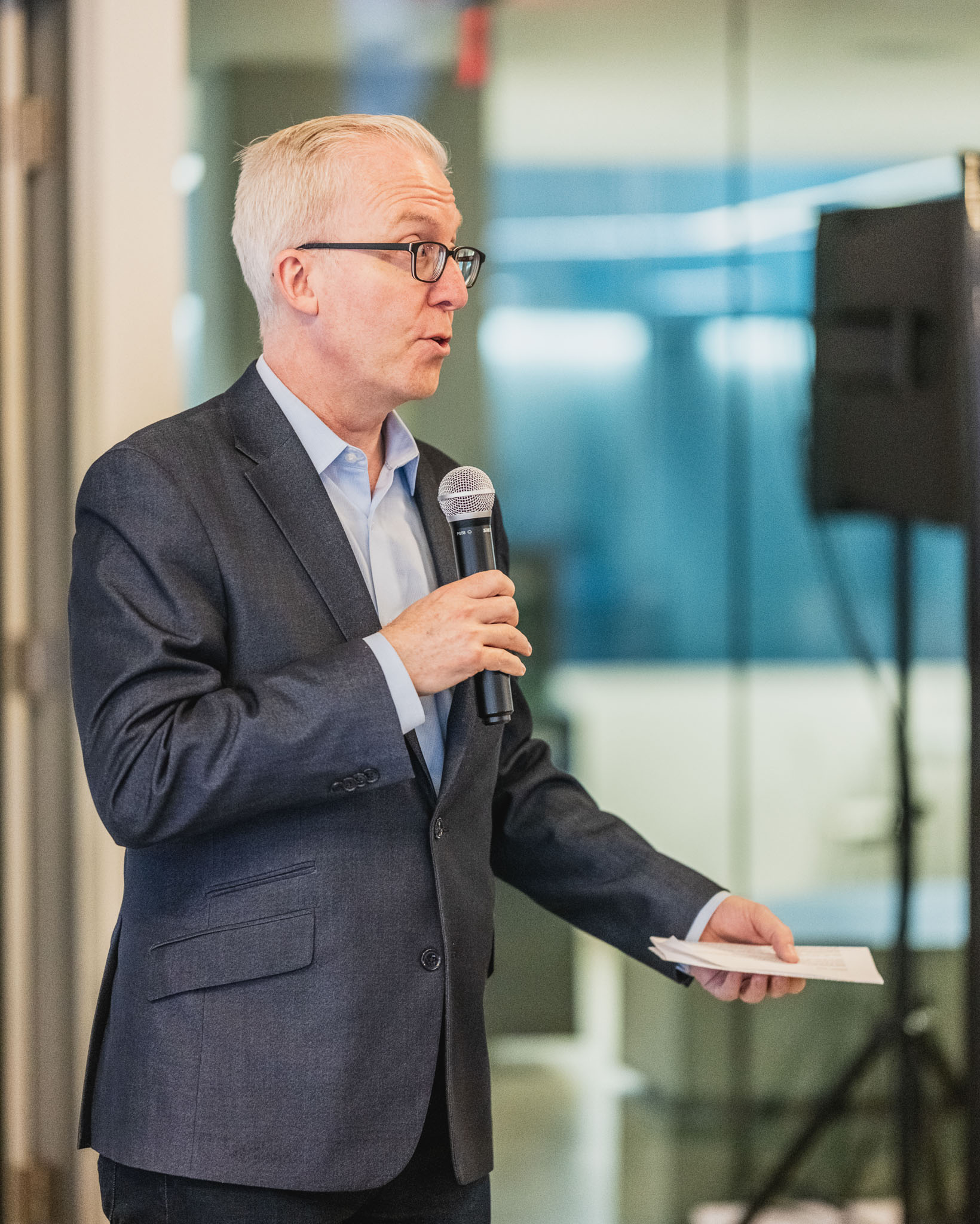 Image of director Alex Gill speaking into a microphone