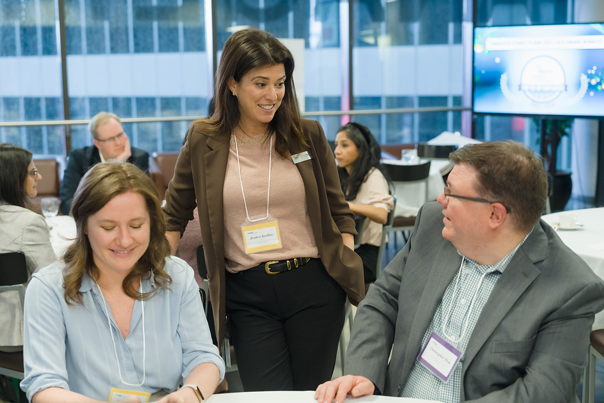 Members of the advisory councils at a table smiling.