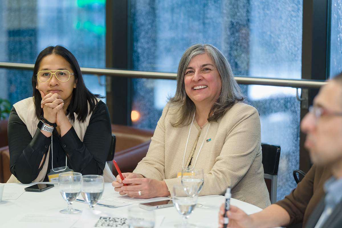 Dean Cynthia Holmes sitting and smiling at the advisory council meeting