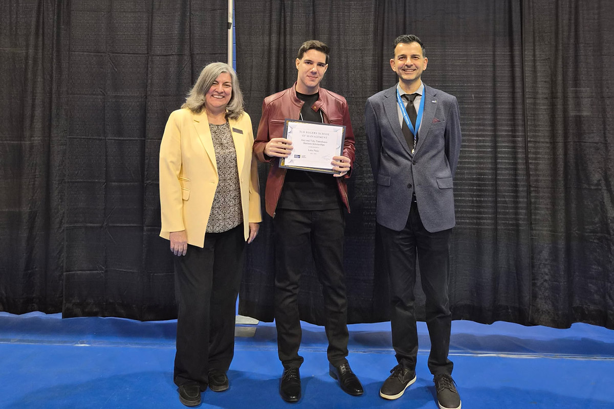 Dean Cynthia Holmes stands beside a student holding a certificate.
