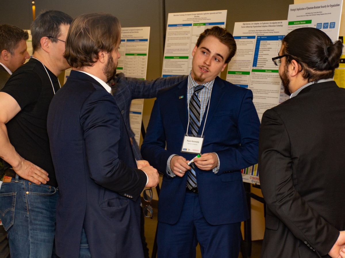 CRL Research Assistant Ryan Kennedy explaining his research to three others.
