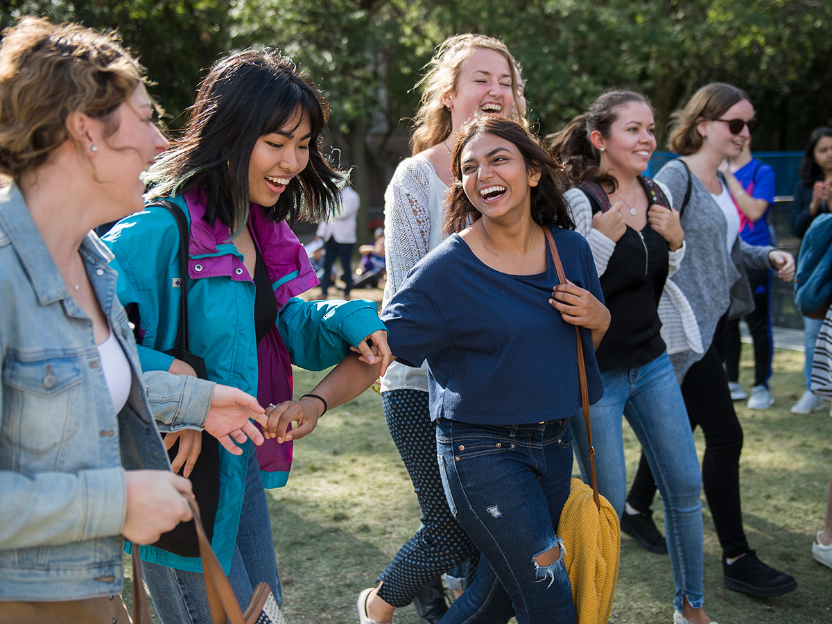 A group of international female students laugh as they walk through the TMU Quad