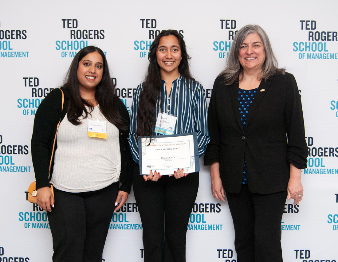 Raina Abesteh standing beside a student receiving an award and Dean Cynthia Holmes