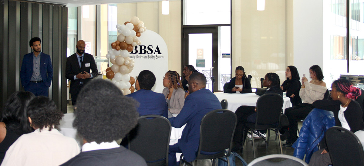 Two speakers and an audience at tables at the BBSA Conference