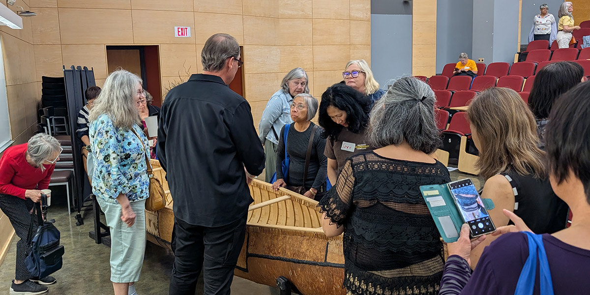 Canoe in conference room with community members around it