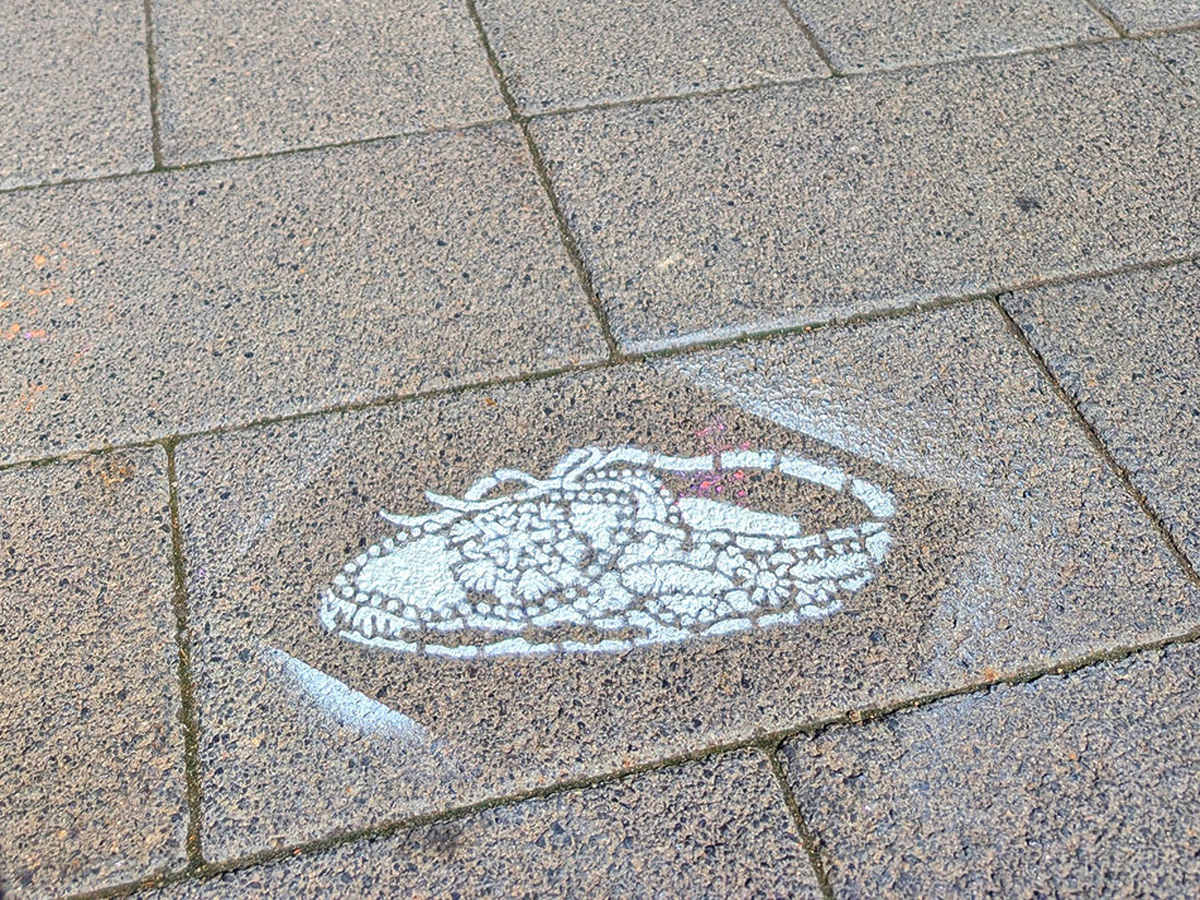 Close up of a stenciled mocassin shoe painted on the pavement