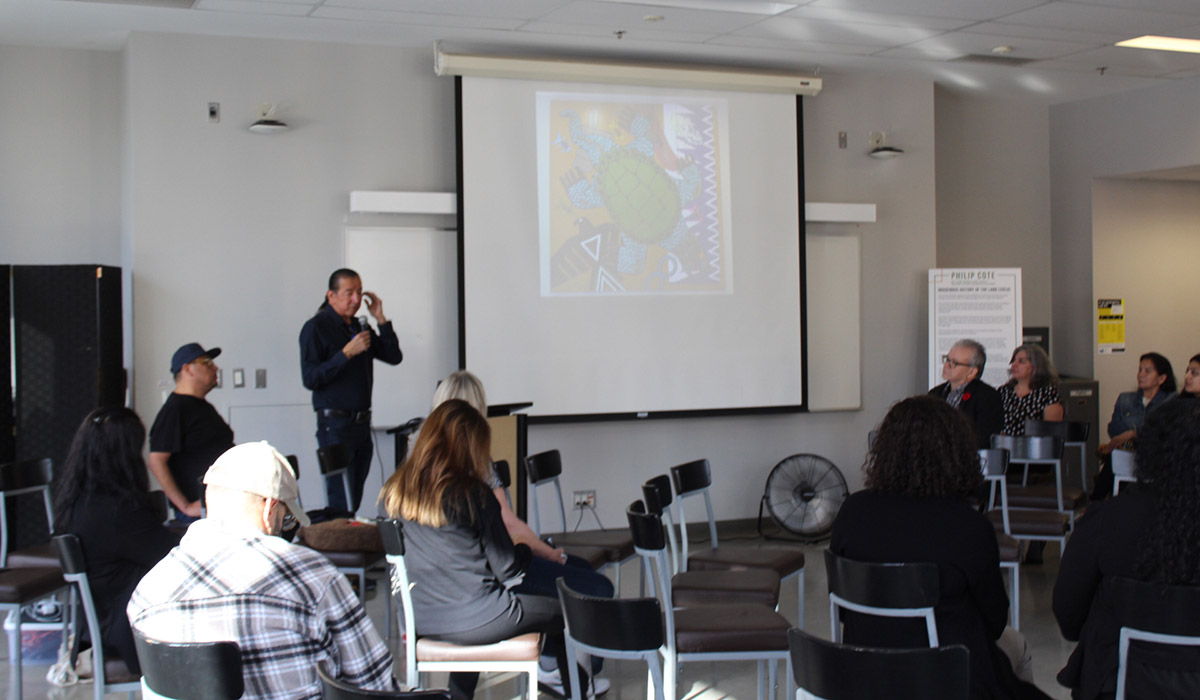 audience listening to Philip Cote mural presentation
