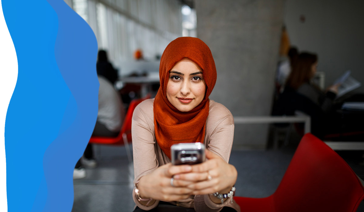 Student wearing a hijab and holding a mobile phone 