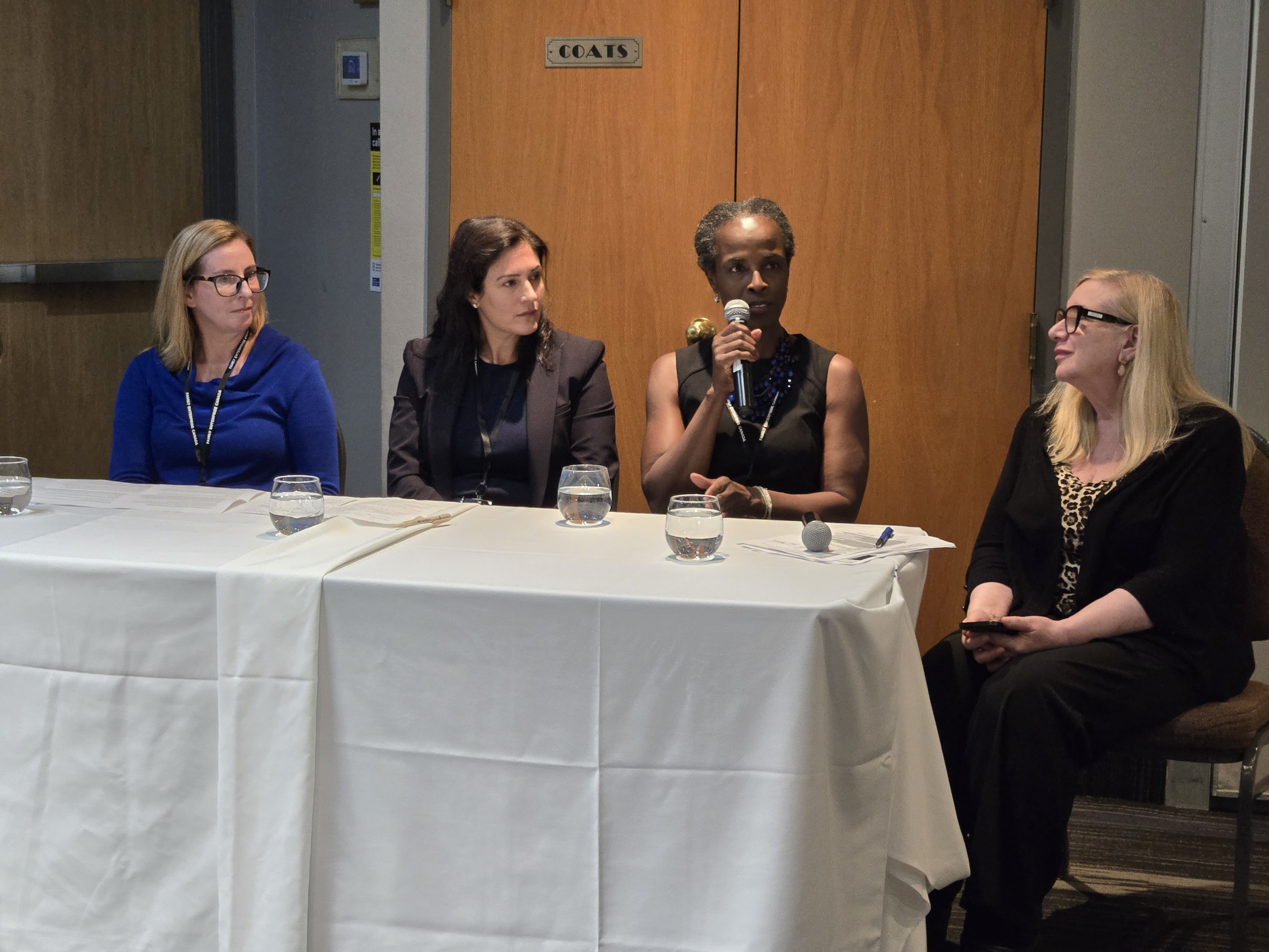 Wendy Cukier moderates a panel discussion with Erica Herbert, Liz McBeth and Christina Sorbara seated at a table.