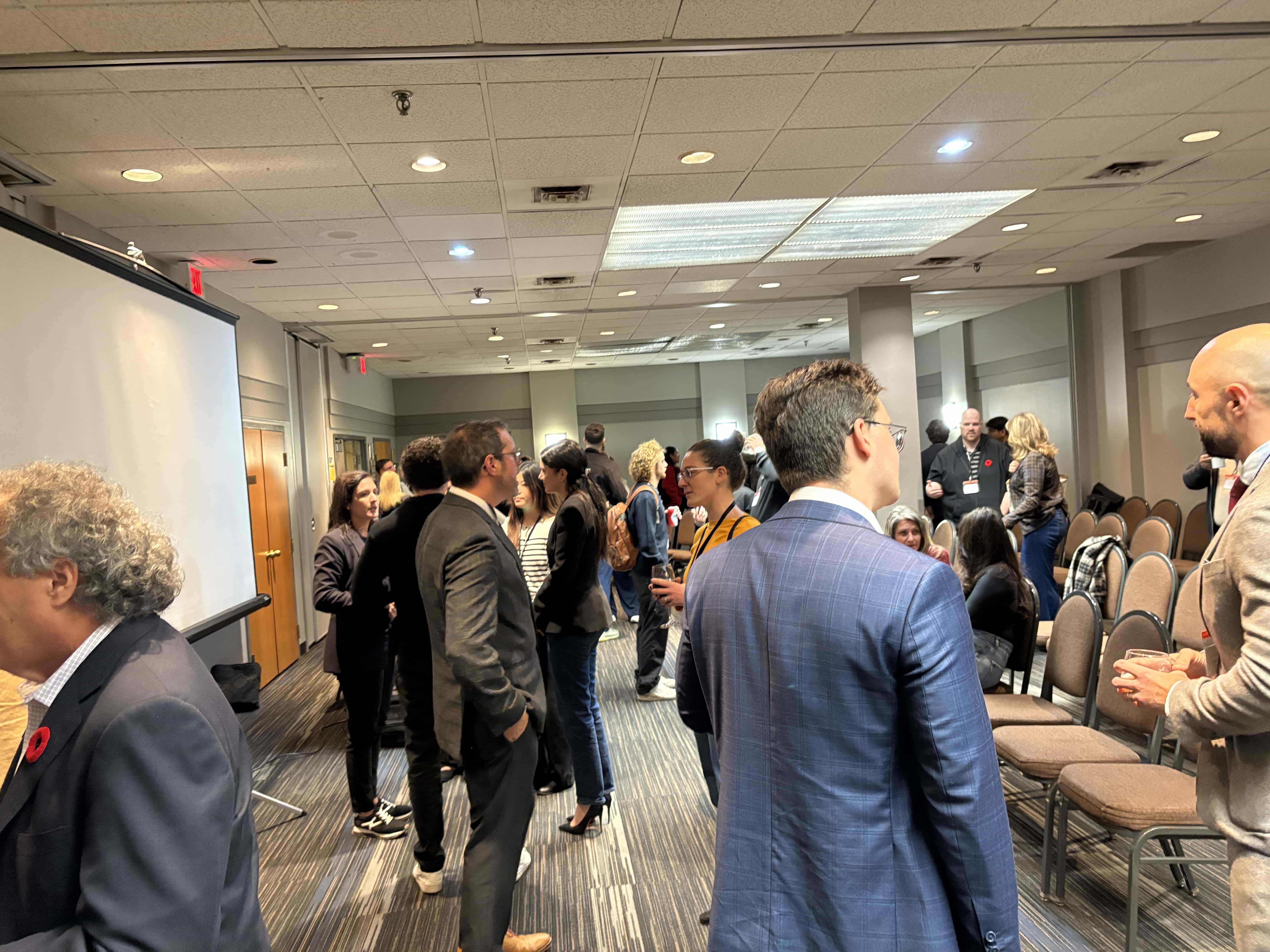 Attendees networking and talking in the event room after the panel concluded.