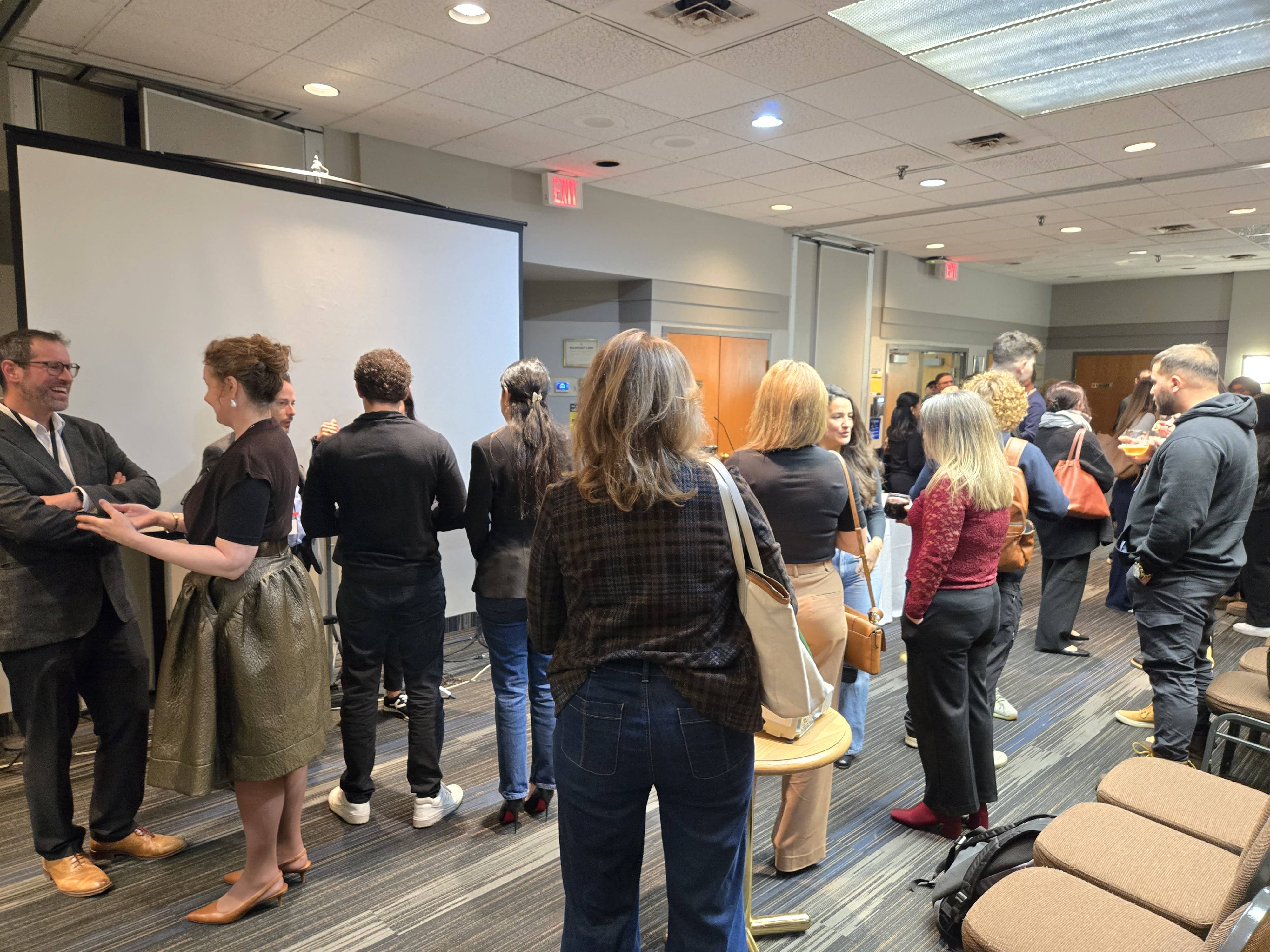 Attendees gathered in conversation throughout the room during the post-event networking session.
