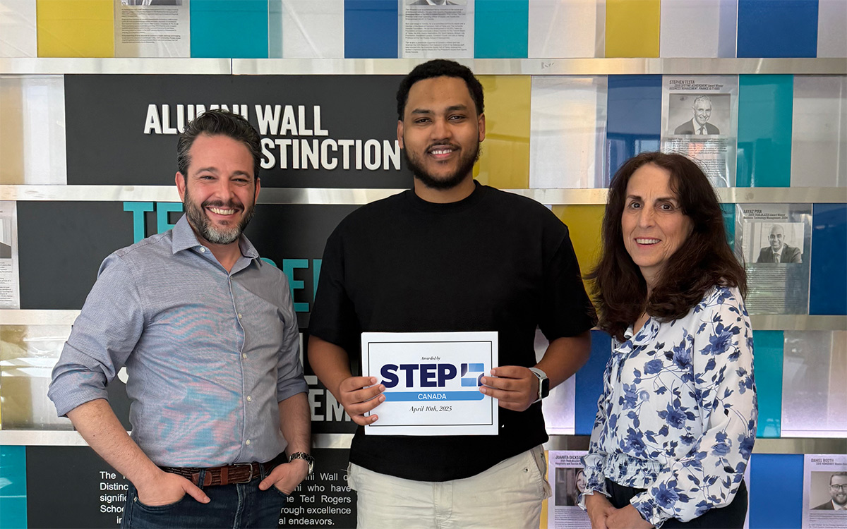 Family Business Institute team with award recipient, Imran Awol, stand smiling in front of the TRSM Alumni wall. Imran holds a STEP Canada certificate.