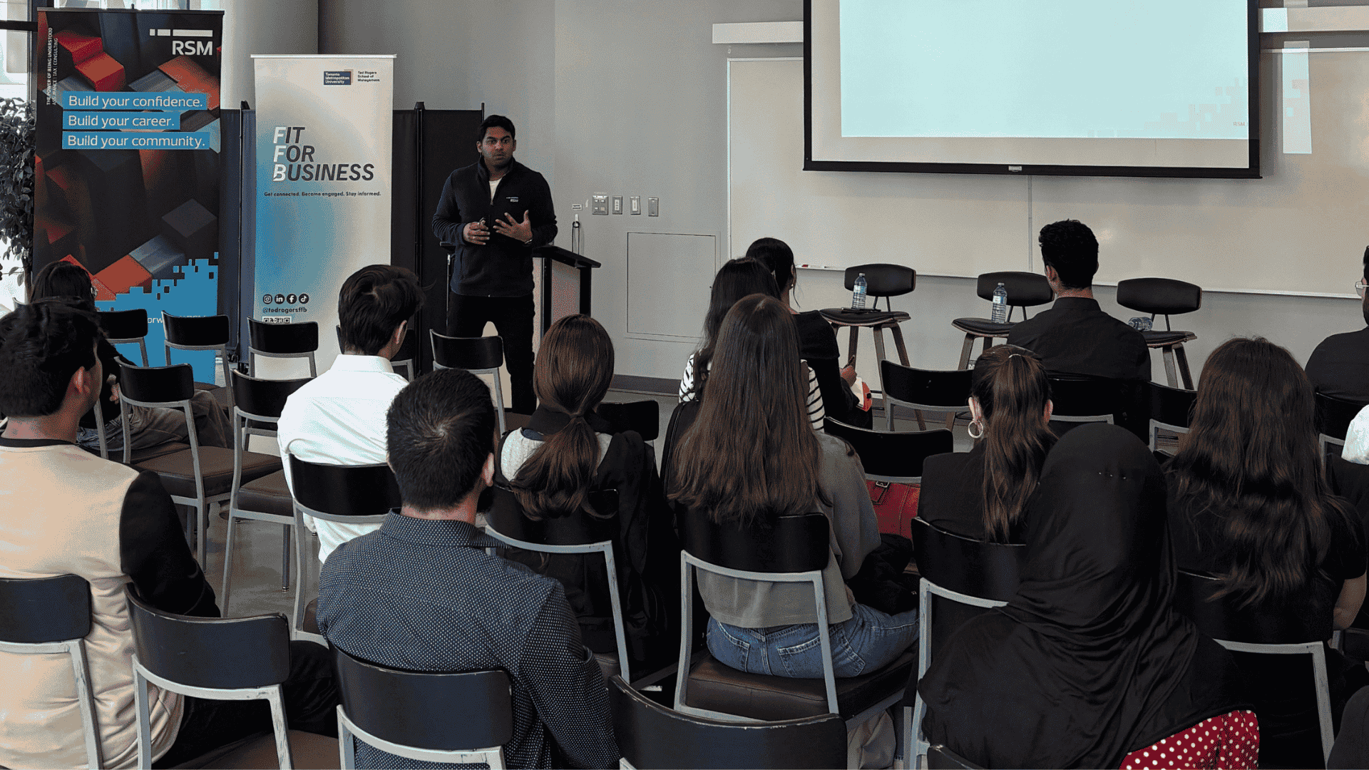 Group of students seated listening to a speaker present
