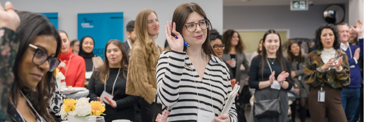 Students raising their hands at a networking event
