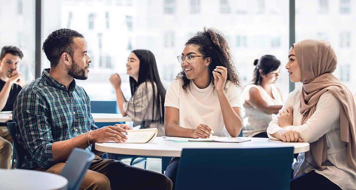 Three diverse students at a table studying