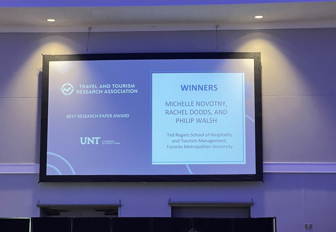 A screen with the winners of the TTRA best paper award.