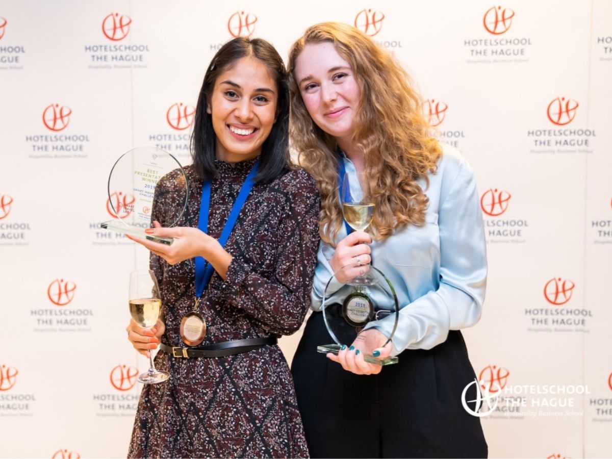 2 students posing with their award