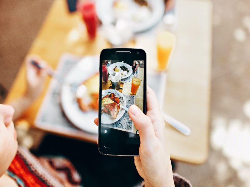 Phone taking a picture of food on a table