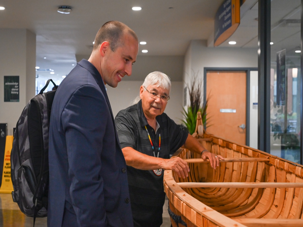 People admiring canoe in Ted Rogers School of Management hallway