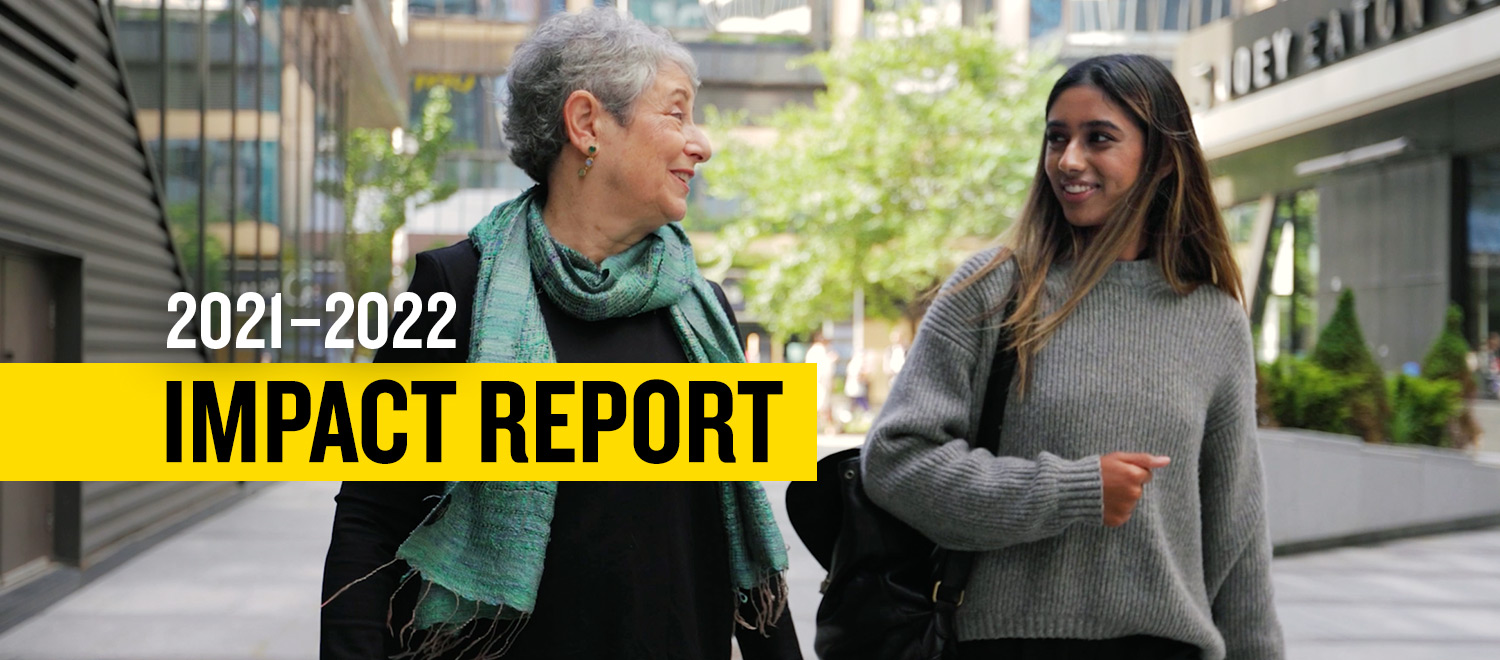 2021 - 2022 Impact Report - Dean Daphne Taras walking on the street talking with a student