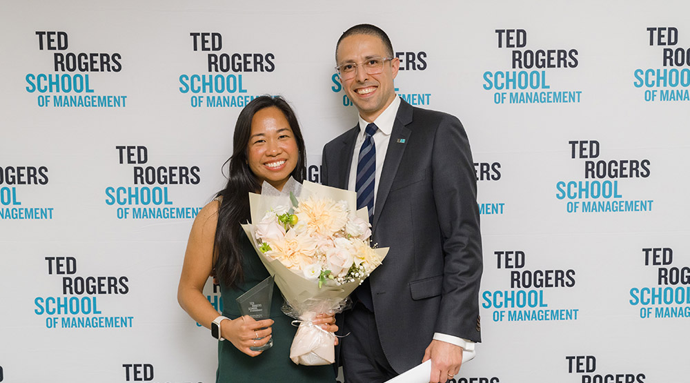 Jacob Alajajian with an alumna accepting an award at the Alumni awards ceremony