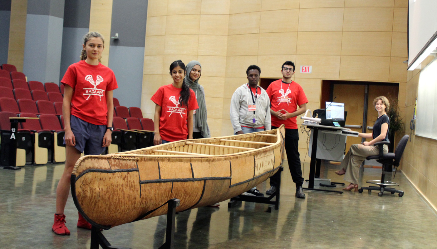 Canoe in conference room with volunteers standing around it