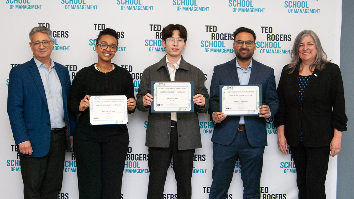 Dean Cynthia Holmes with three student award recipients holding their certificates at the Student Awards Celebration