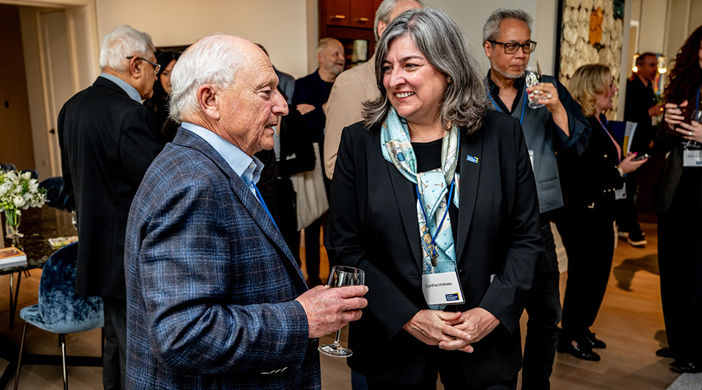 Dean Cynthia Holmes talking to Dr. Brian Segal during an event