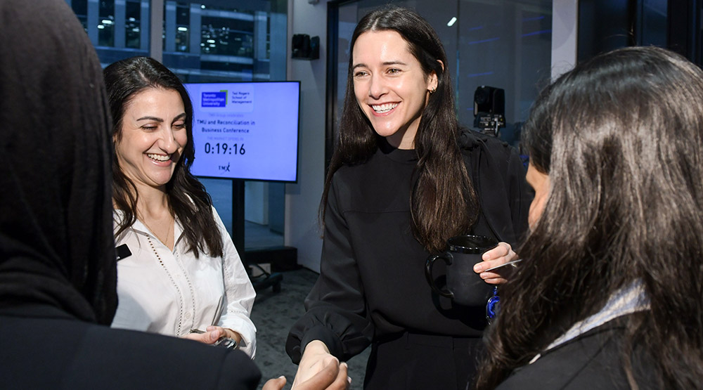 Shaking hands at a TMX, TMU and Reconciliation in Business Conference