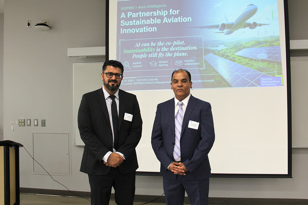 Dr. Vik Sing and Aaron Dalal, CEO of Aero Intelligence in front of a presentation screen with an airplane and title "A partnership for Sustainable Aviation Innovation"