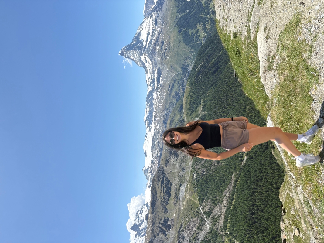 student taking picture in front of mounain region
