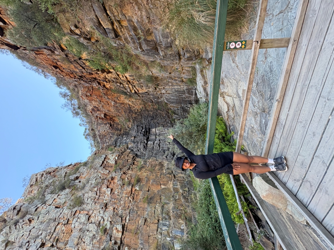 student standing in front of scenic background wth rocks in australia