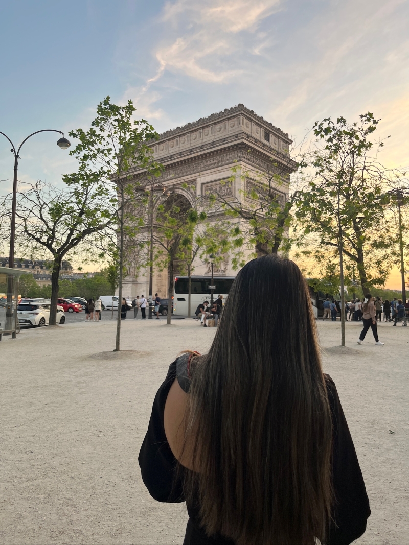 student walking in front of a building at sunset in france