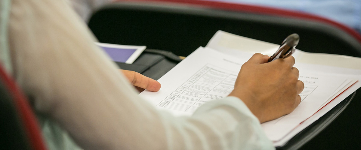 Student writing in lecture hall