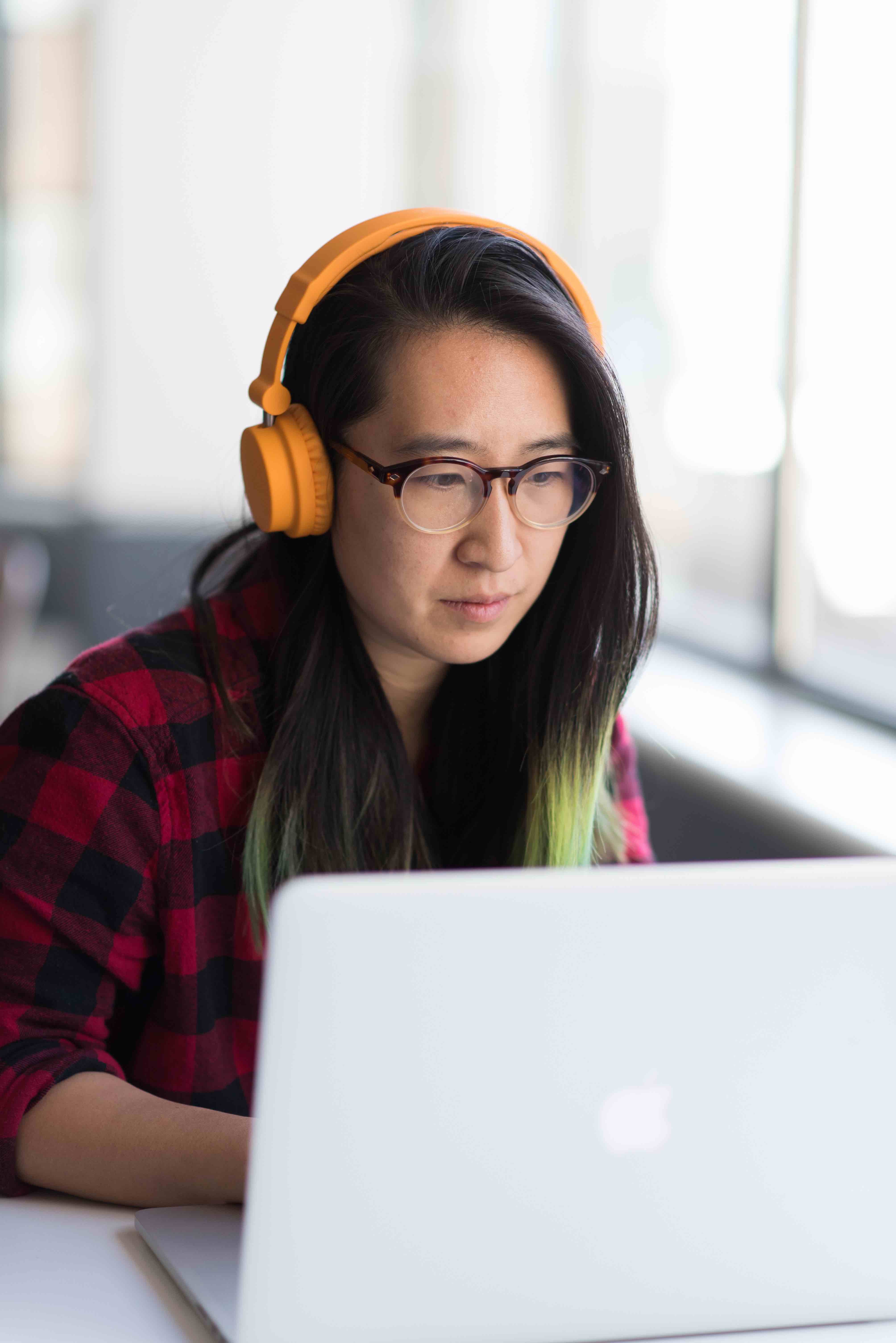 Woman wearing headphones working at her computer.