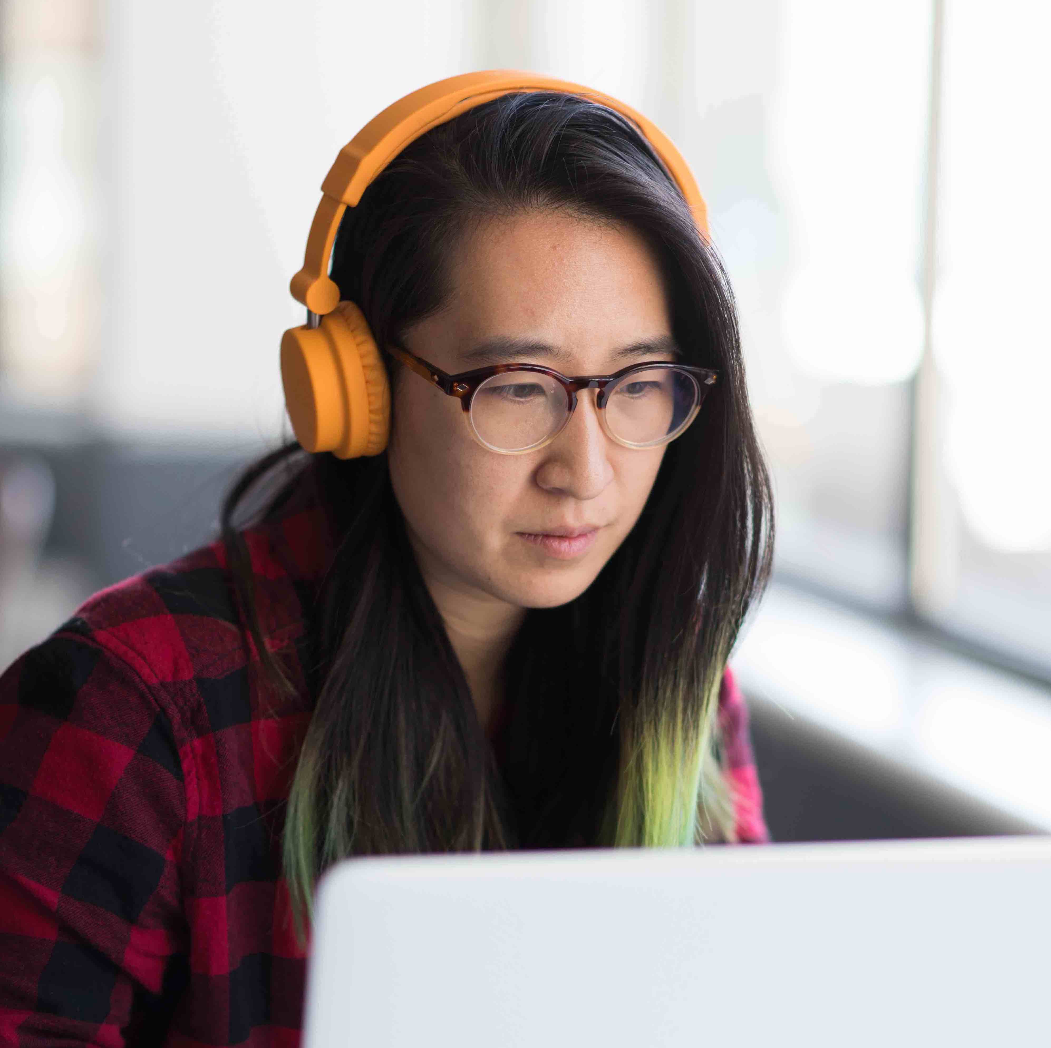 Woman wearing headphones working at her computer.