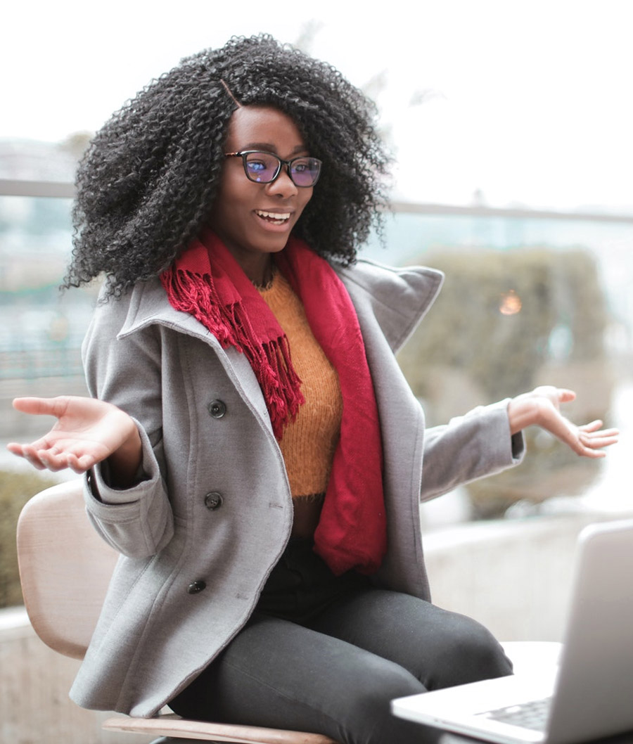 Cheerful woman sitting with laptop in front of her