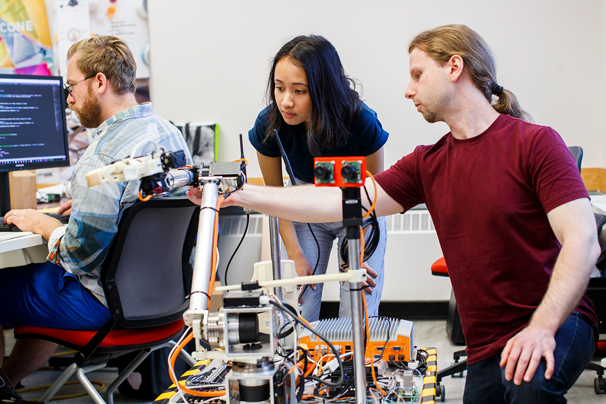 Students in lab for urban innovation experiments looking at a prototype