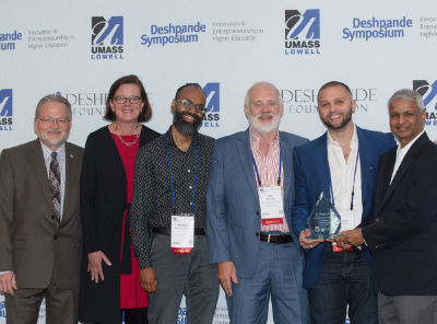Six male and female adults posing for a picture with their newly-won trophy