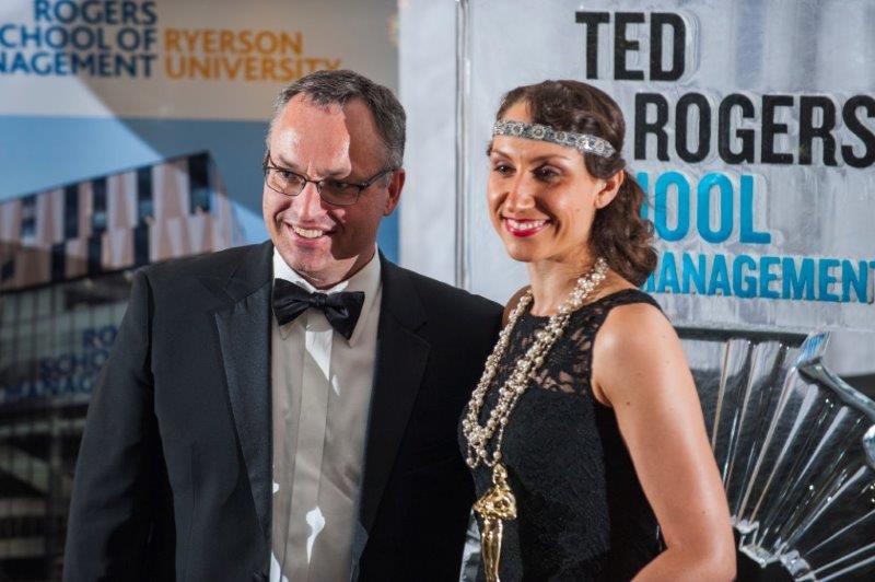 Dean and a woman wearing 1920s inspired dress and accessories posing for a picture