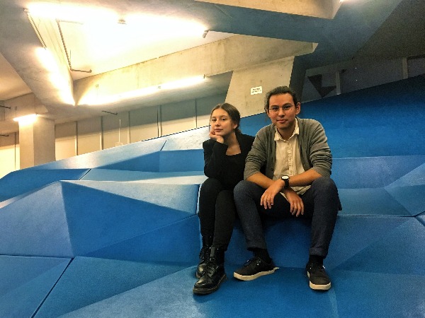 Two students sitting on blue geometric shapes 