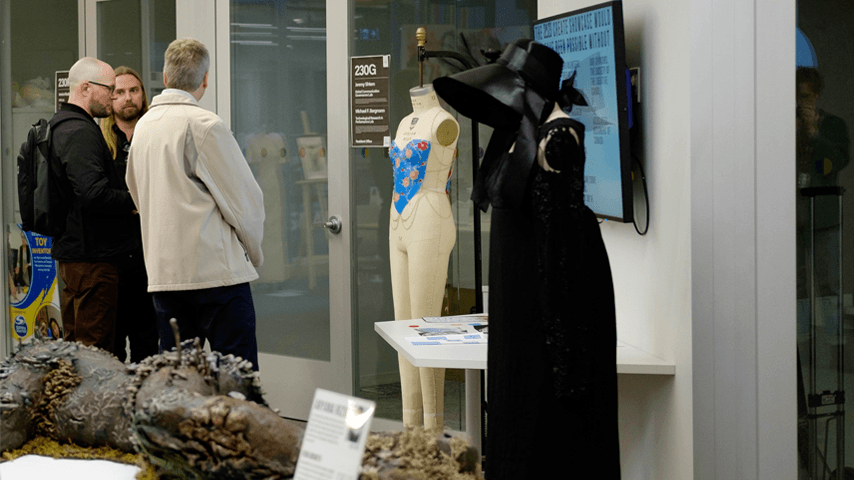 Faculty members looking at a corset display during CREATE 2023