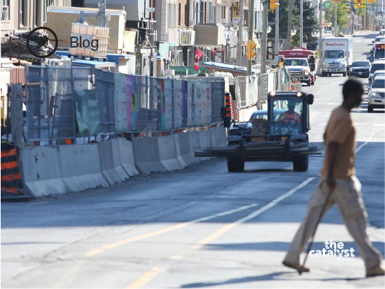 Black man walking across the Eglinton construction site 